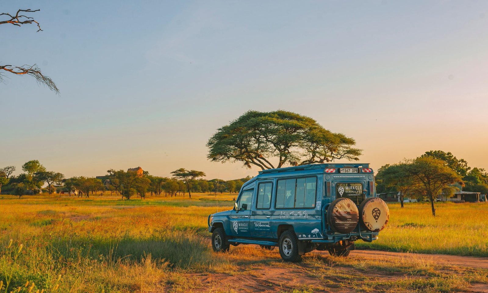Safari vehicle crossing the East African savannah at golden hour